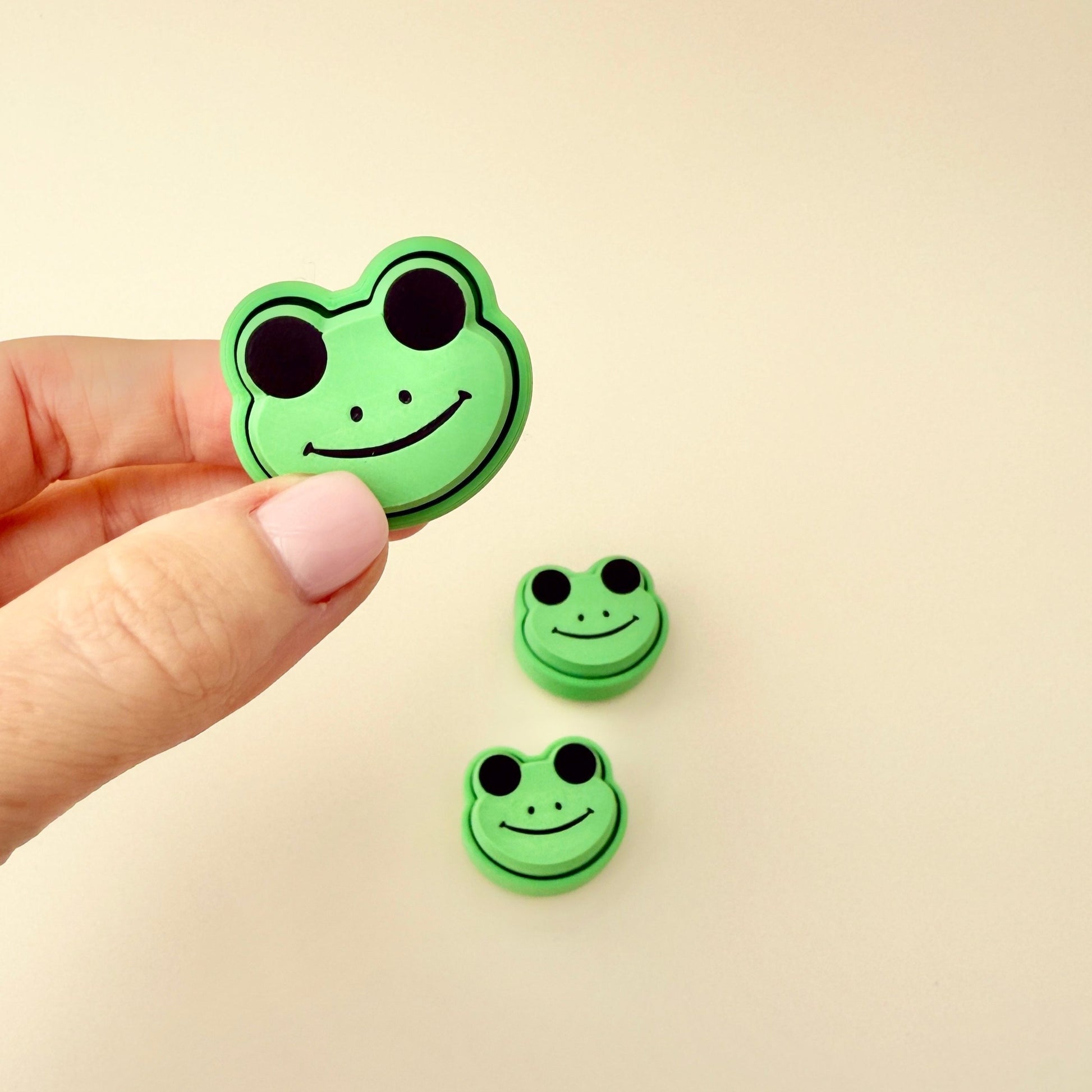 Compact frog clicker fidget toy, 3cm in size, with black eyes, nose, and mouth, ideal for sensory play.