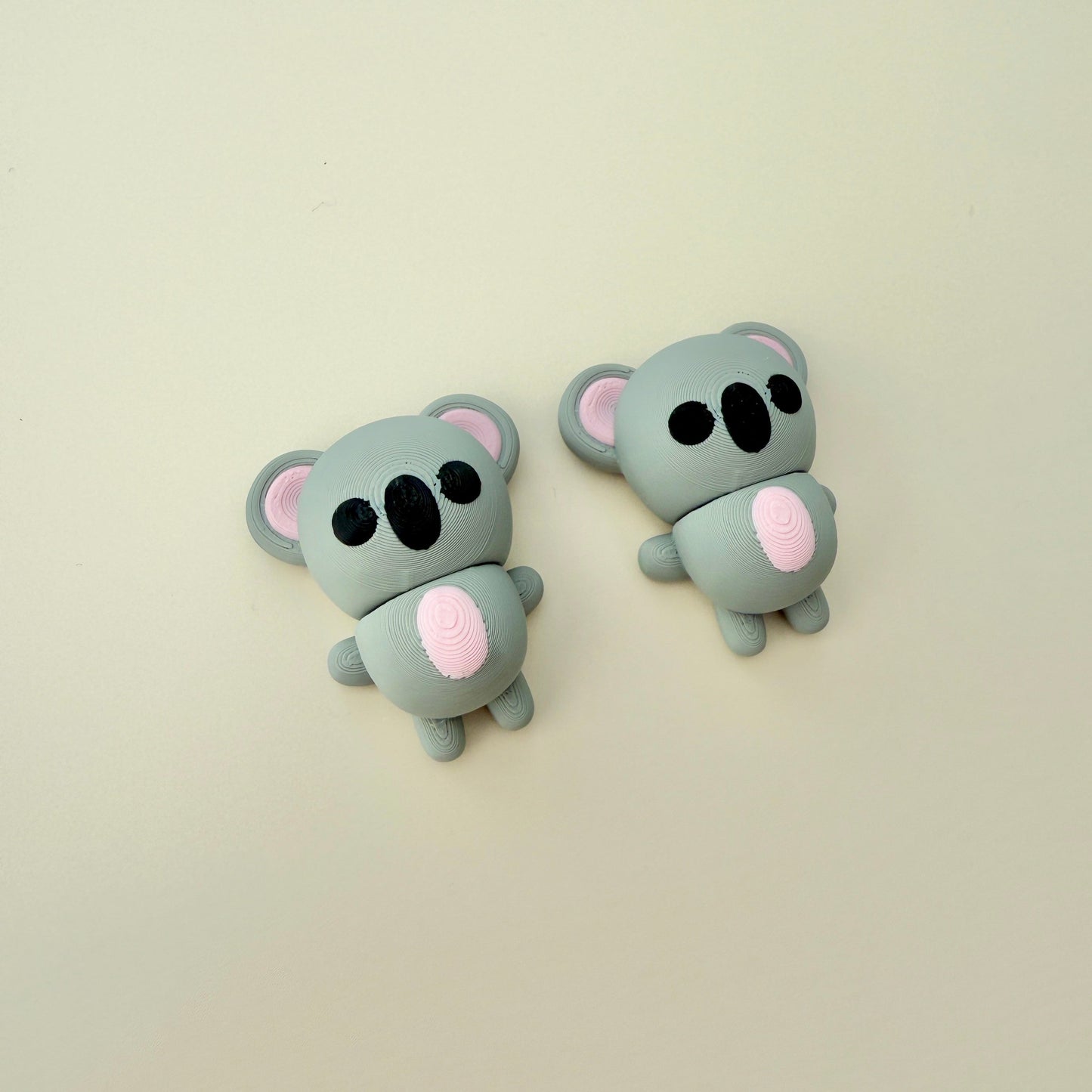 Small grey koala fidget toy with black eyes and pink tummy, perfect for calming sensory play and on-the-go fidgeting

