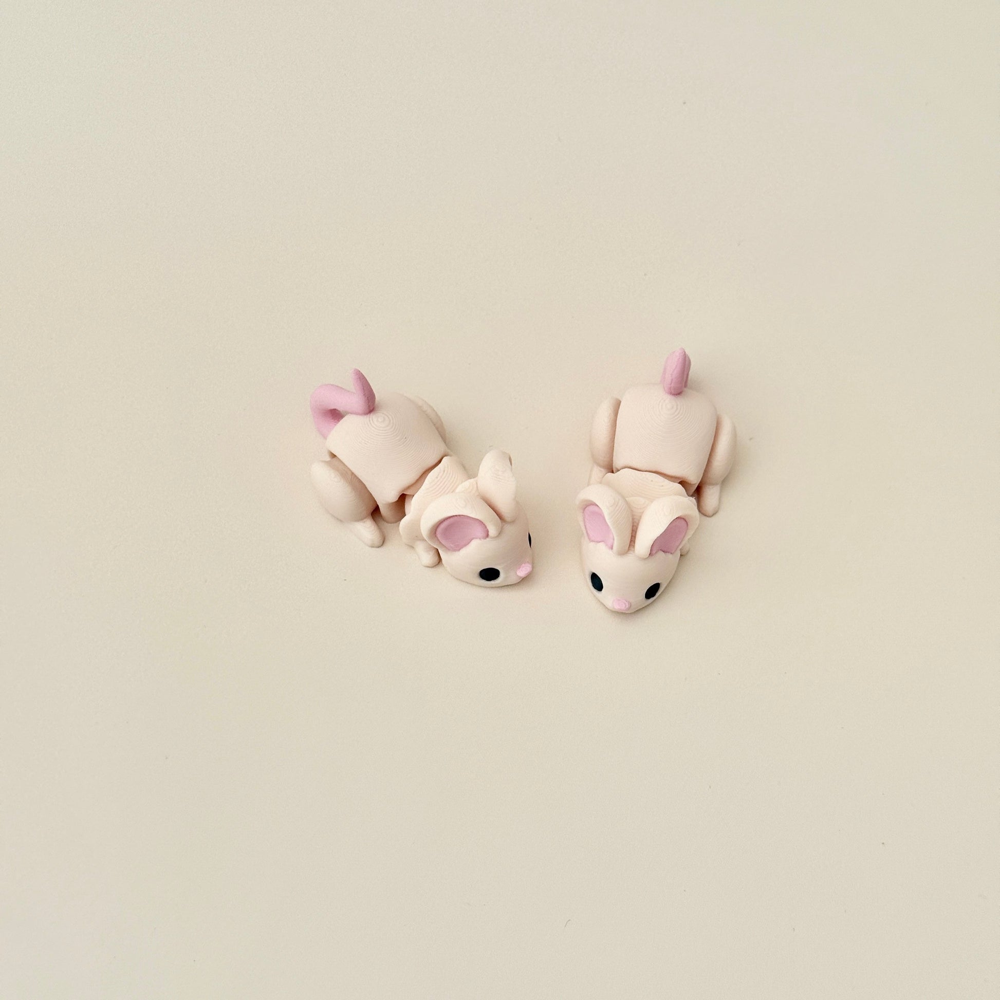 Fully articulated beige mouse fidget toy with pink details, 6.5cm long, designed for stress relief and sensory play.