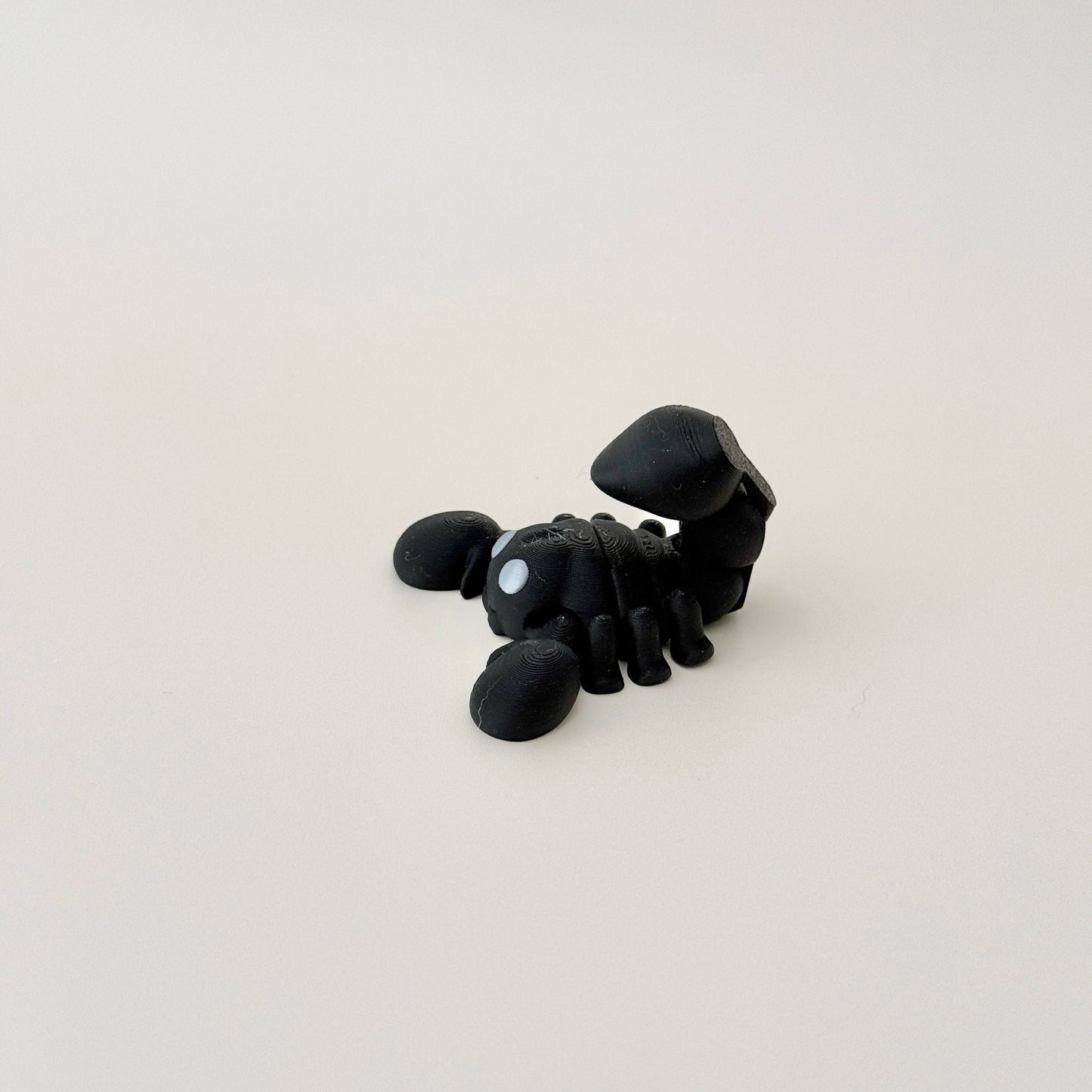 Miniature scorpion fidget toy, black with silver eyes, fully flexible with moveable tail, great for collectors.