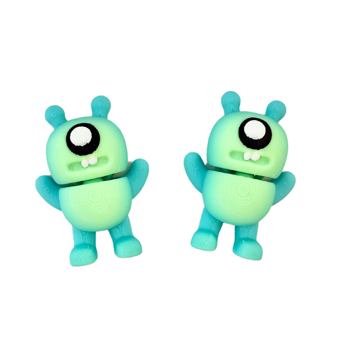 Adorable alien monster fidget toy featuring black and white googly eyes, flexible body, and a spooky yet cute design.