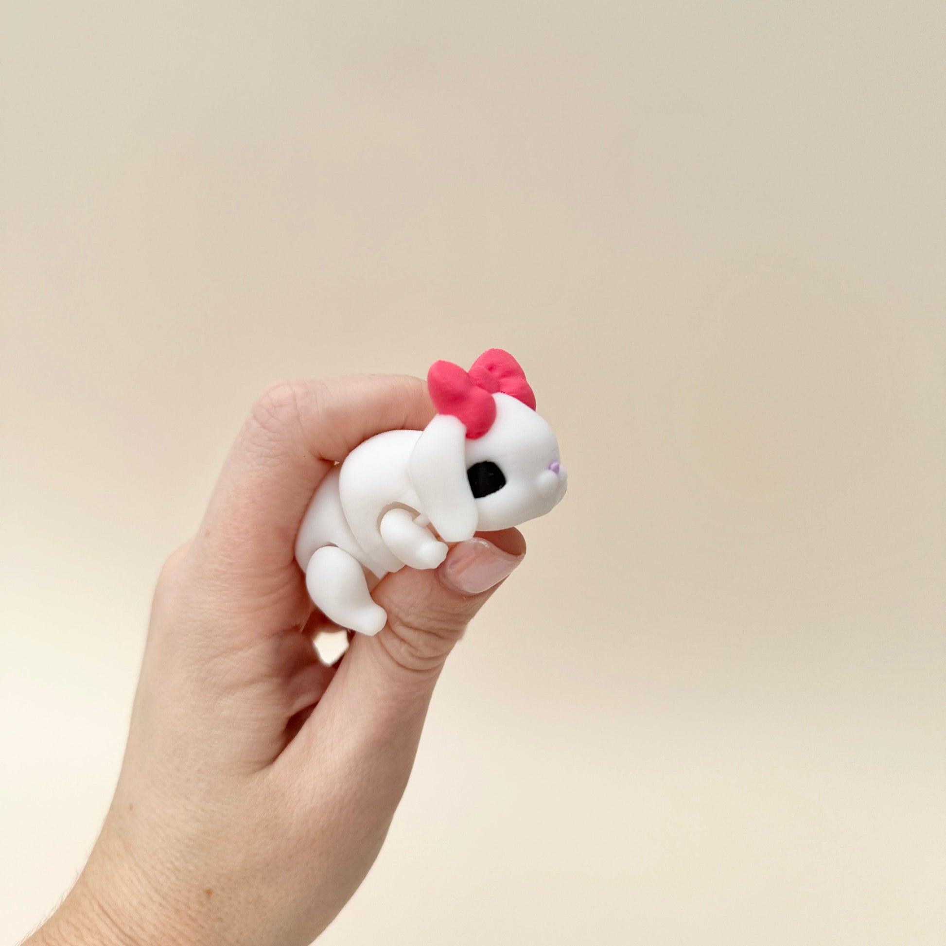 Flexible bunny fidget toy with smooth articulation for stress relief, available in beige and white designs.