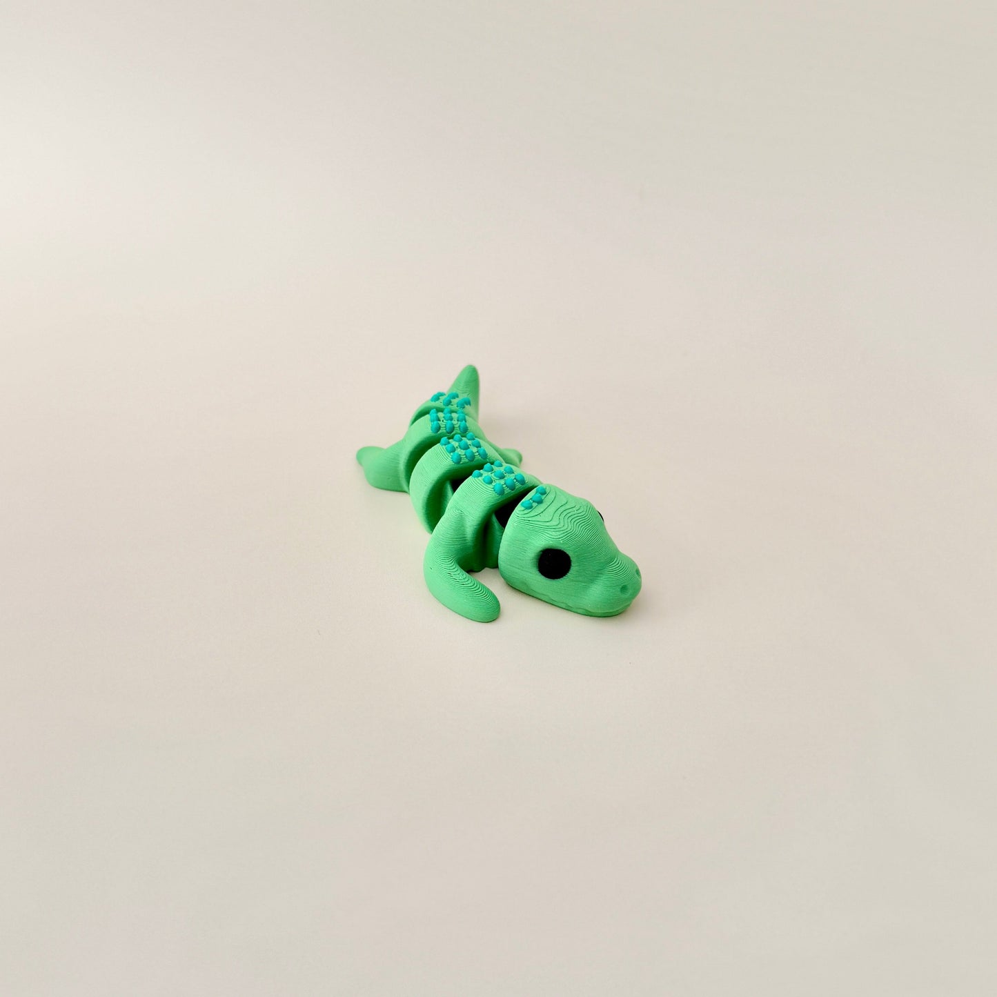 Realistic crocodile fidget toy with green body and spikey scales for smooth movement and sensory engagement.