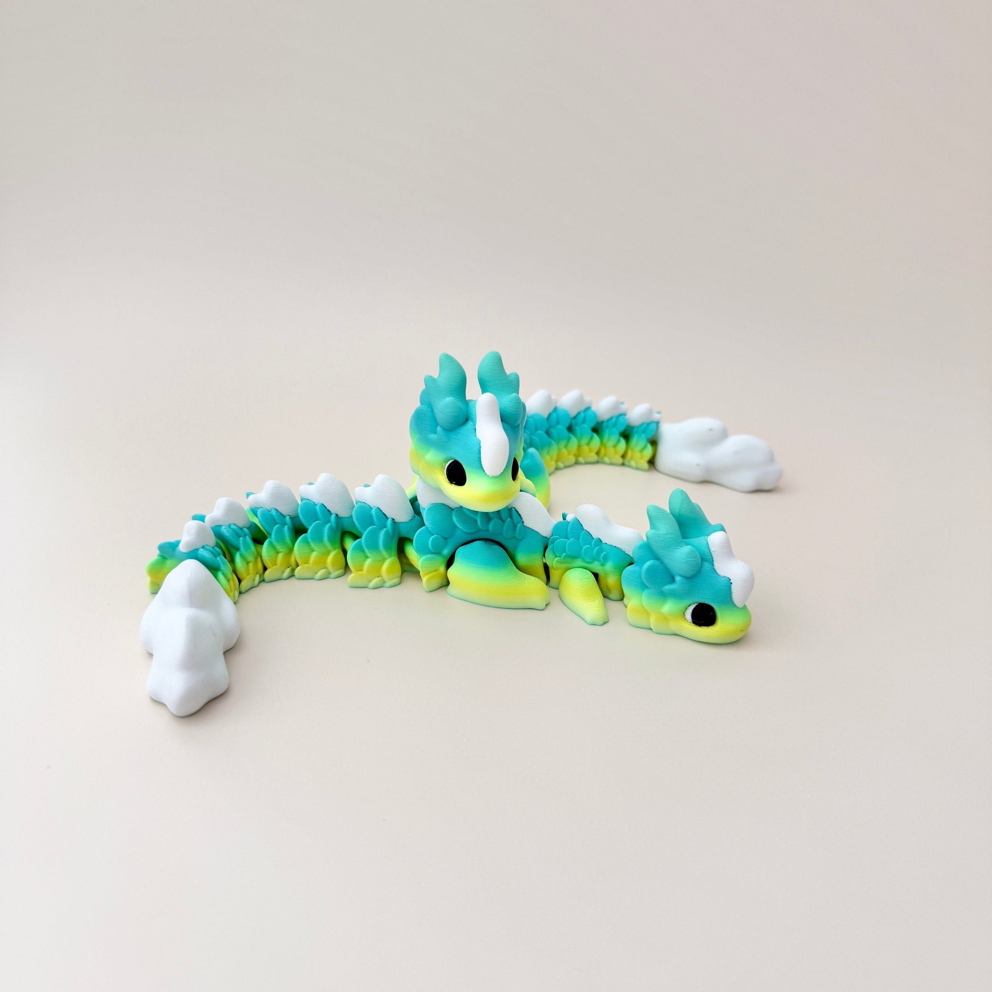 Large dragon fidget toy with a vibrant yellow, blue, and green gradient, featuring white spikes and movable parts.