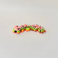 Colourful gecko fidget toy in vibrant shades with black spots and black and white eyes, designed for sensory play.