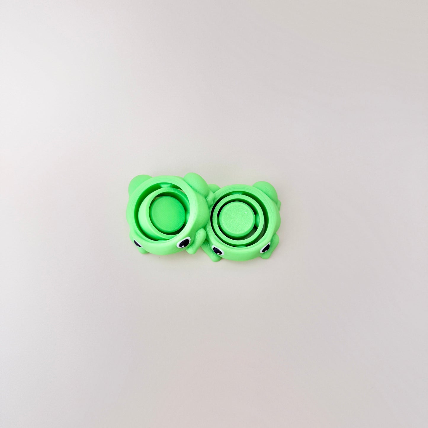 Compact 4cm frog fidget spinner with black and white eyes, ideal for portable fidgeting.