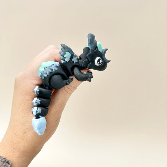 12cm black and sparkly dragon fidget toy featuring articulated wings, tail, and celestial details.