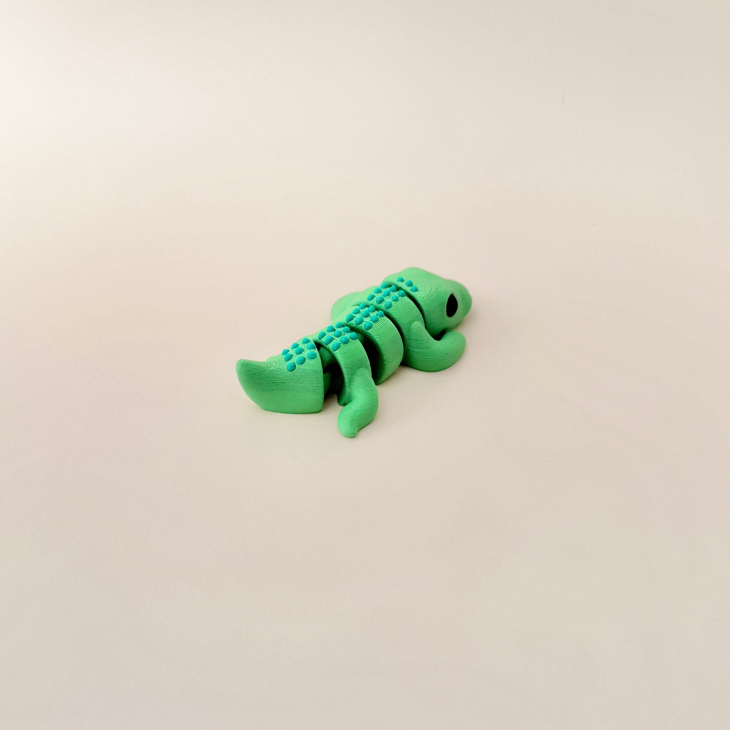 Realistic crocodile fidget toy with green body and spikey scales for smooth movement and sensory engagement.