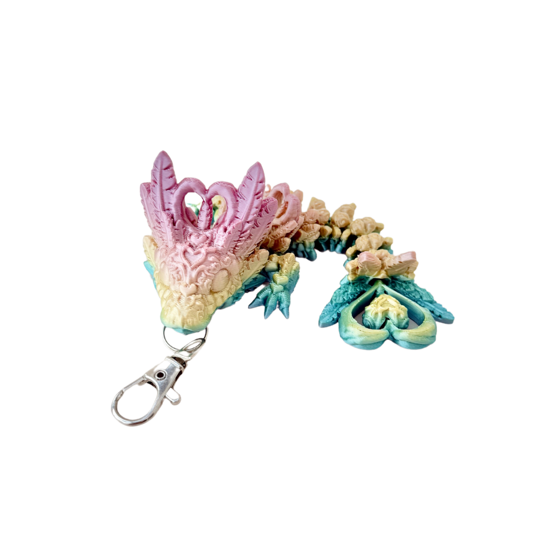 Heart Dragon Tadling keyring with shiny rainbow colouring and intricate details, including heart-shaped features.