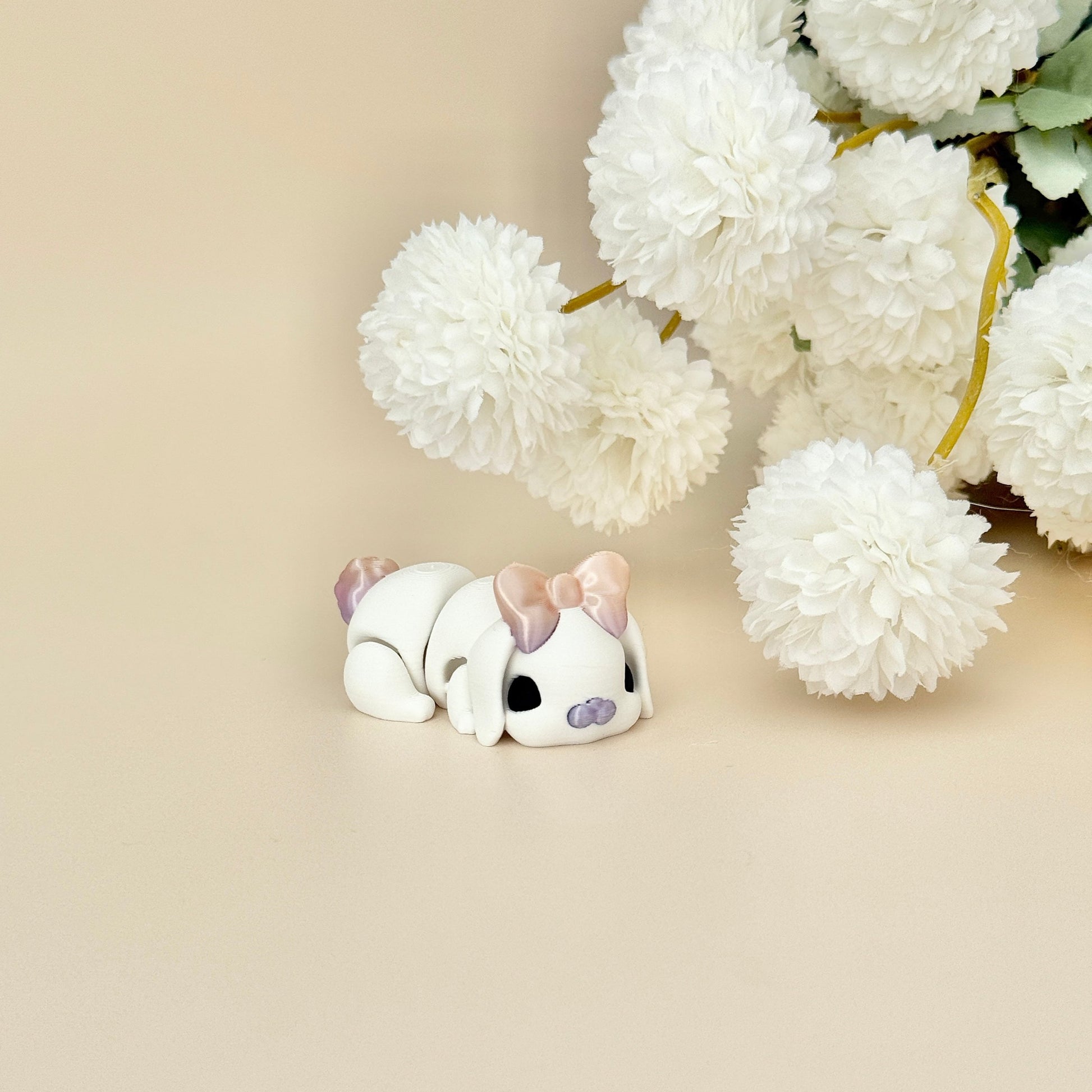 White bunny with iridescent nose, tail, and bow, designed for fidgeting and stress relief.