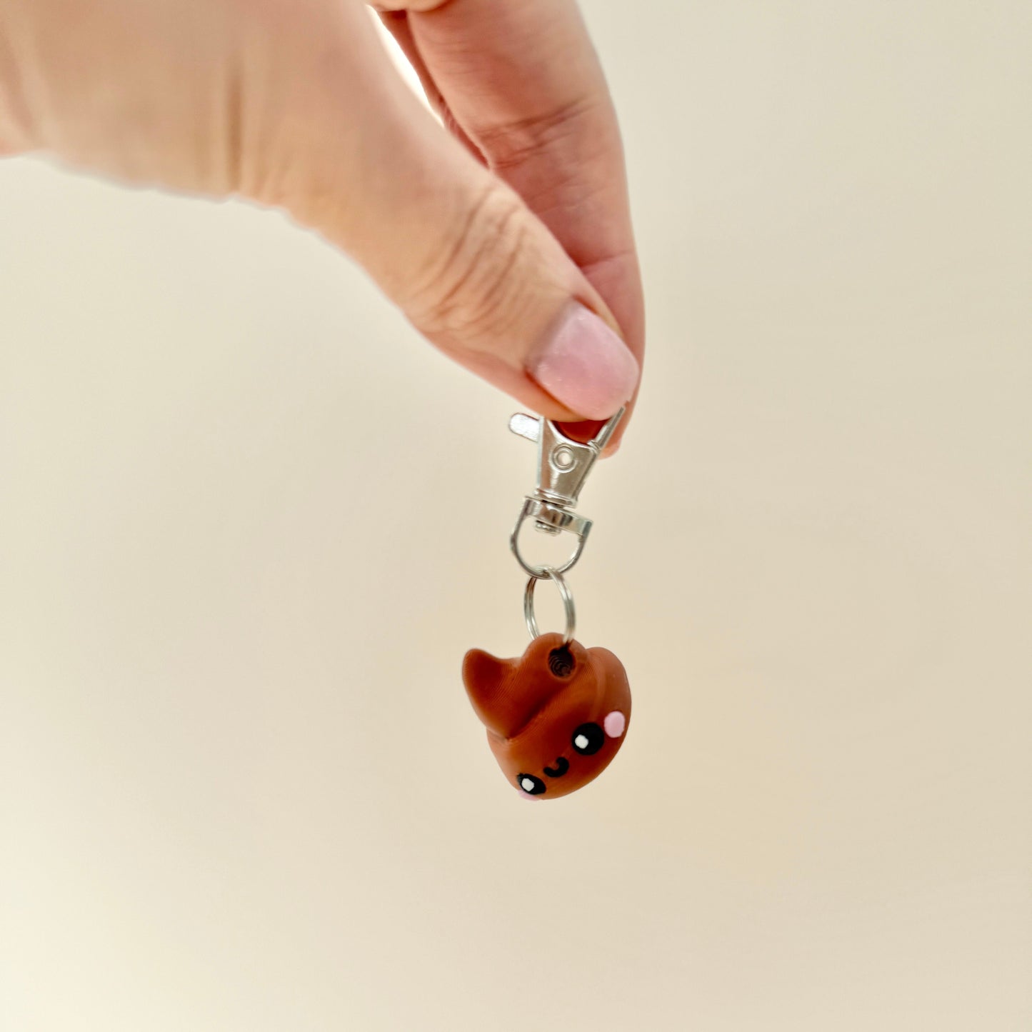 Toilet roll and poop keyring duo with cheerful designs and fun details.