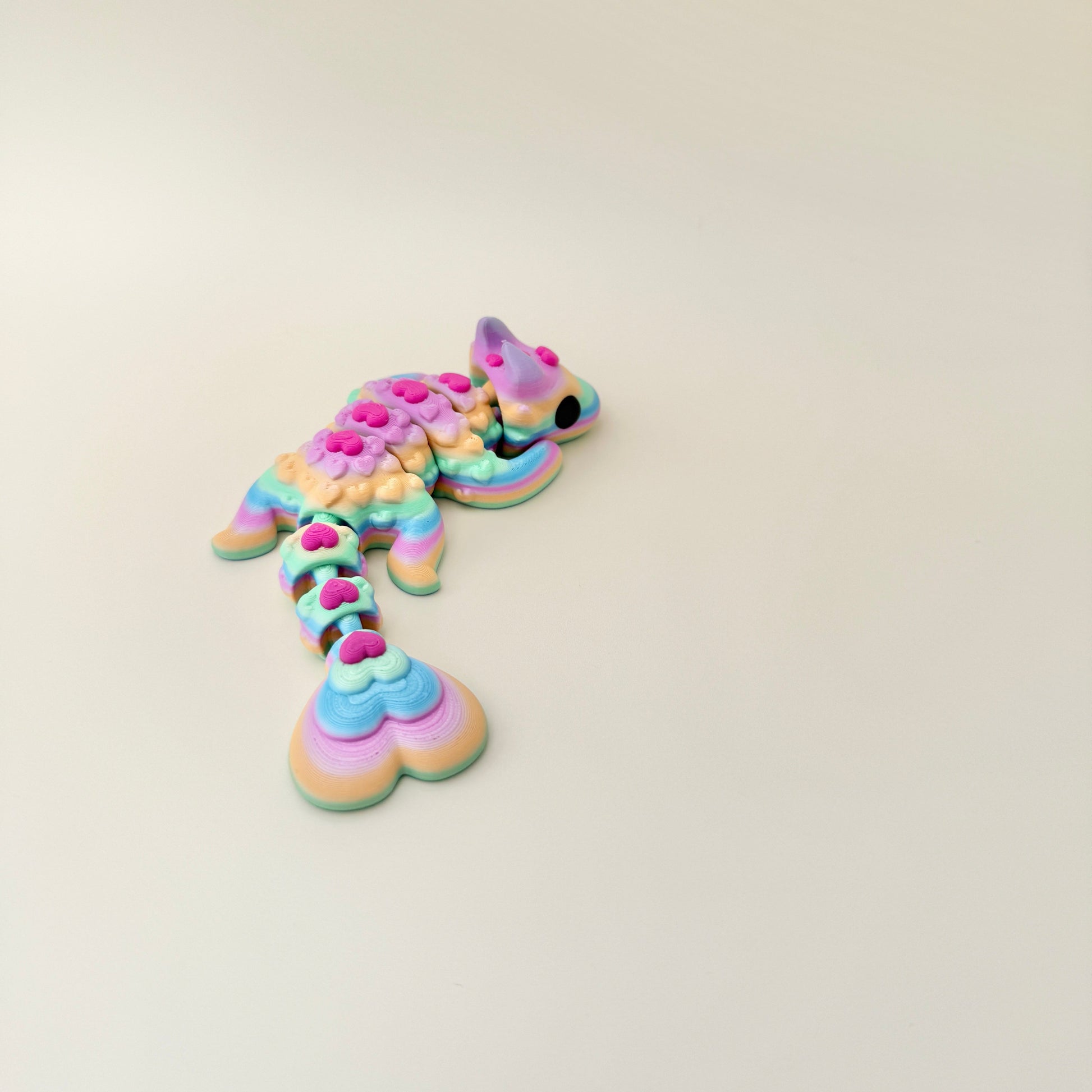 Bright rainbow Lovebug Dragon with pink hearts and smooth movement, great for collectors and sensory play.