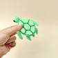 Large turtle fidget toy with multiple clickable spots, black eyes, and flexible legs, head, and tail.