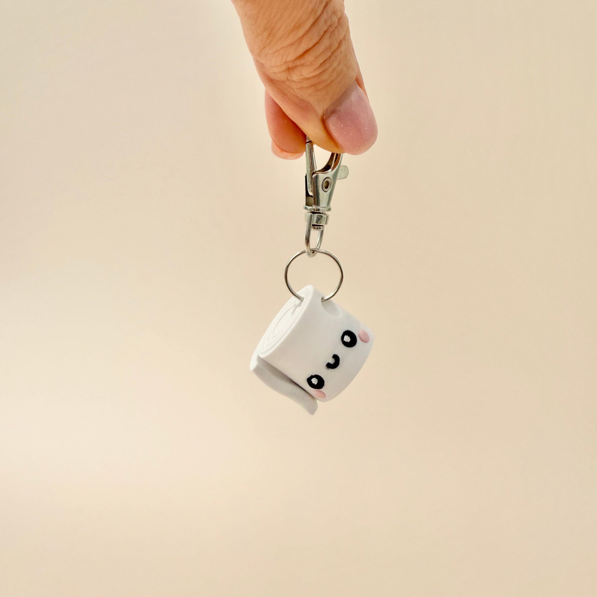 Pair of kids’ keyrings including a smiley toilet roll and a brown poop character.