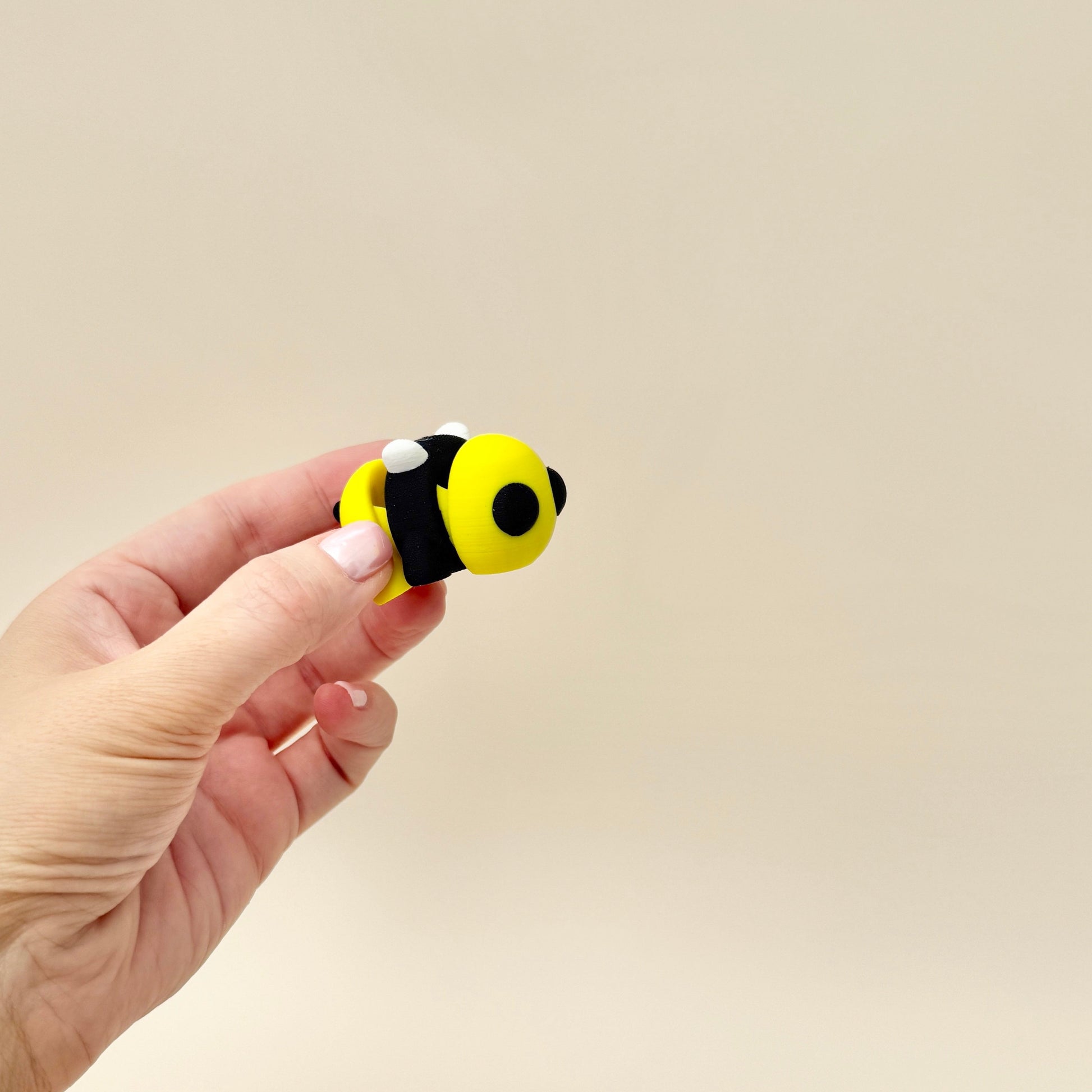 A small, 5cm bumble bee fidget toy with detailed stripes and moveable wings.