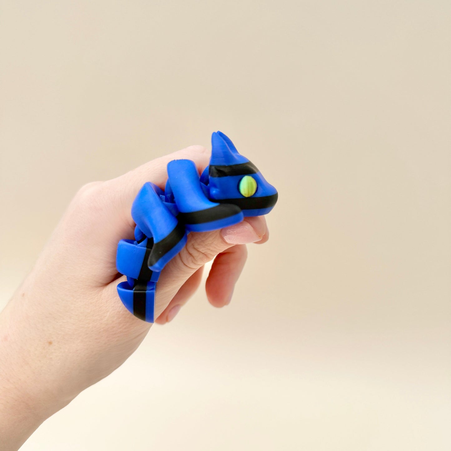 Miniature dragon fidget toy in vibrant gradient and striped designs for tactile sensory engagement.