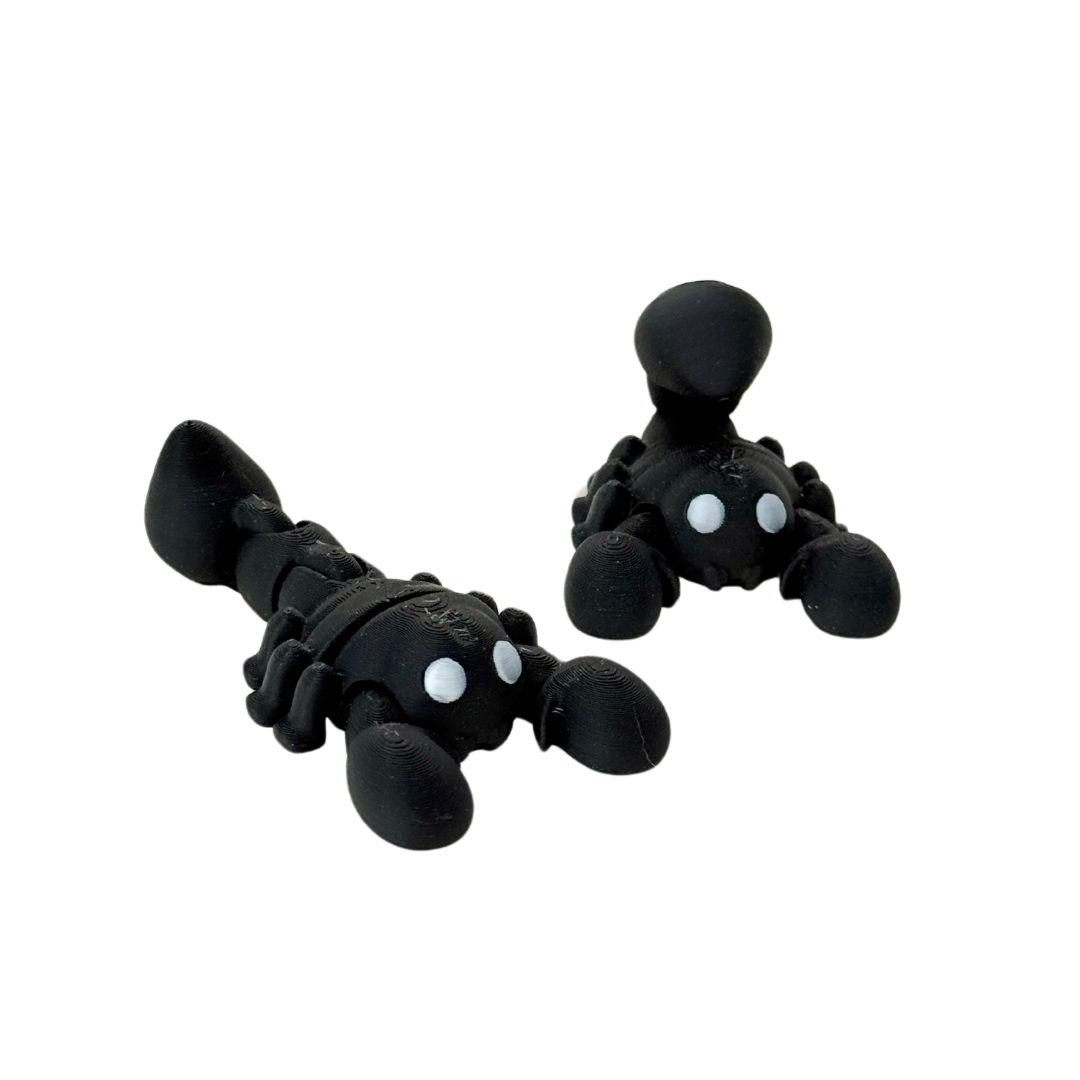 Black scorpion fidget toy with silver eyes and flexible tail, 7cm in length, designed for sensory play.