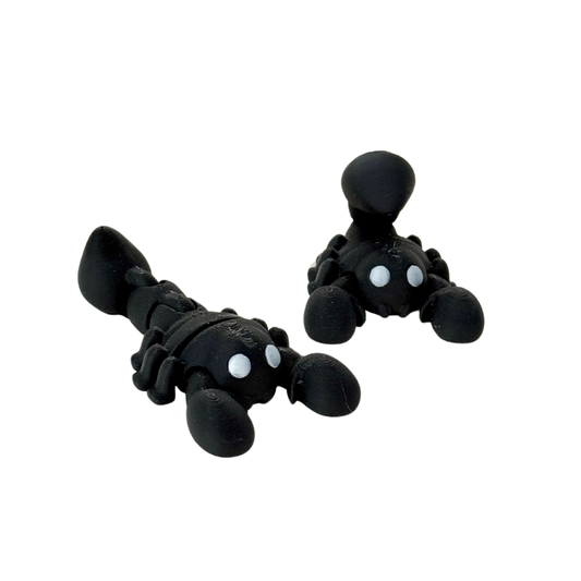 Black scorpion fidget toy with silver eyes and flexible tail, 7cm in length, designed for sensory play.