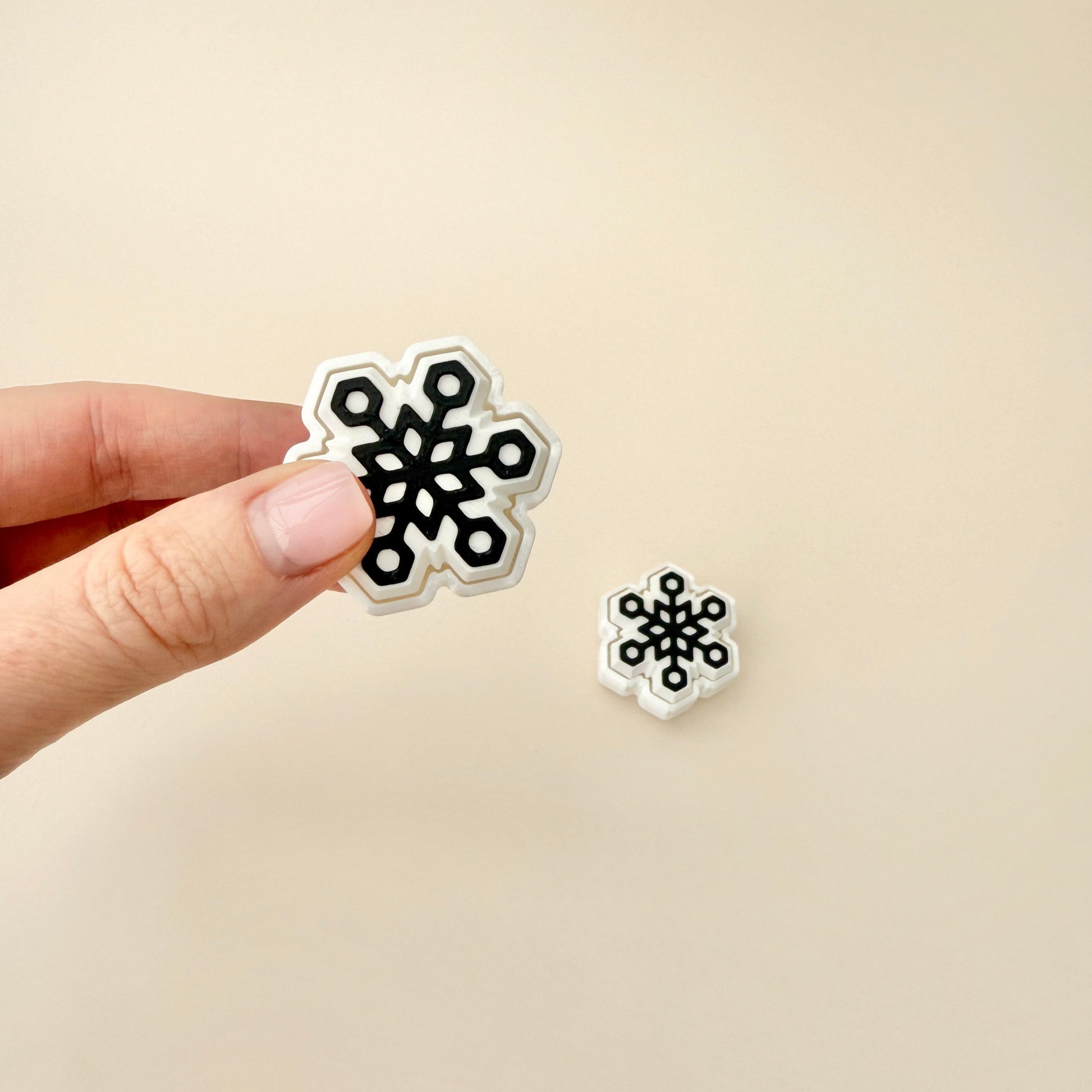 Snowflake fidget toy in white, 4cm in size, with a black snowflake pattern, designed for tactile engagement.