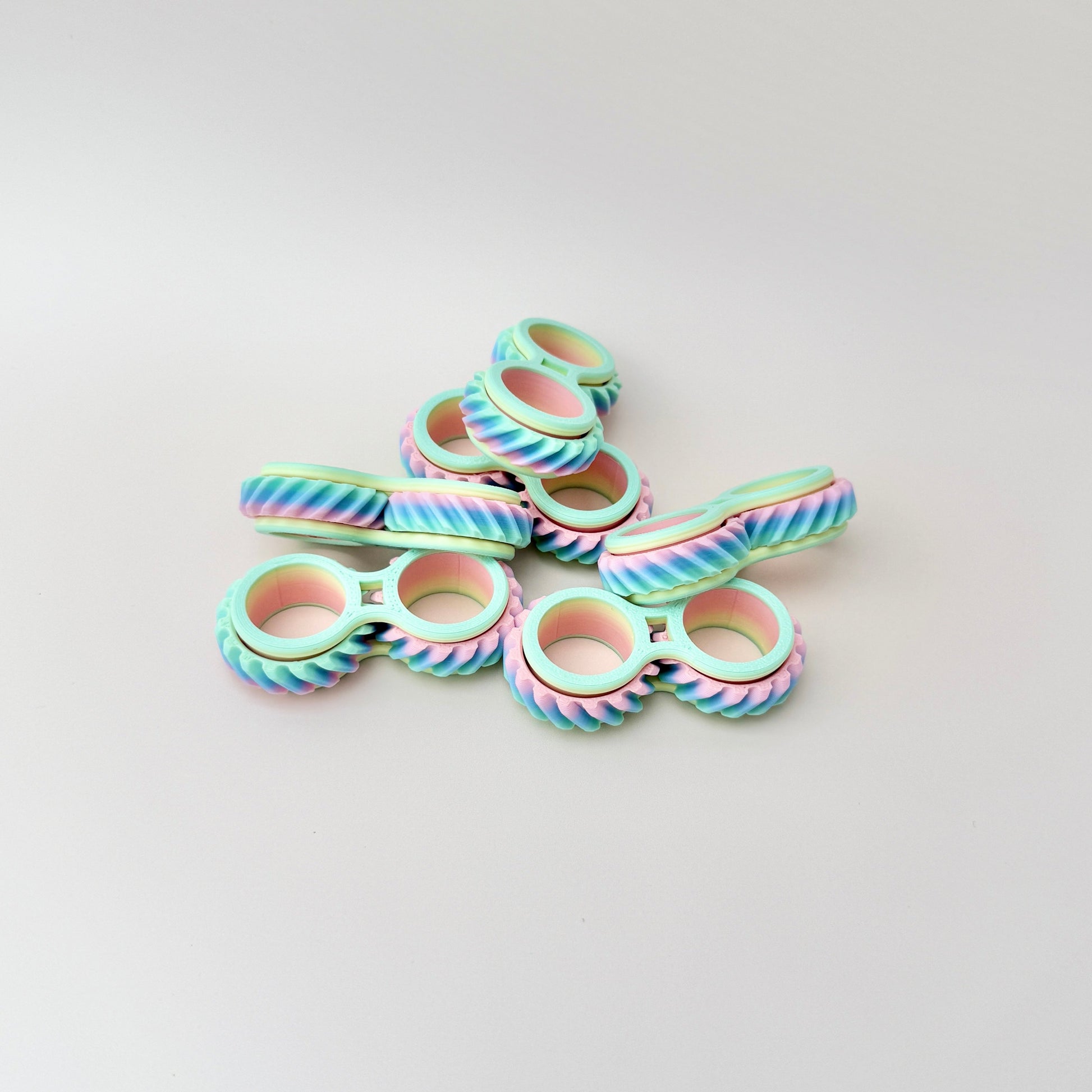 Twist & Roll fidget toy, 6cm in length, featuring two interlocking wheels that spin and twist on the fingers.