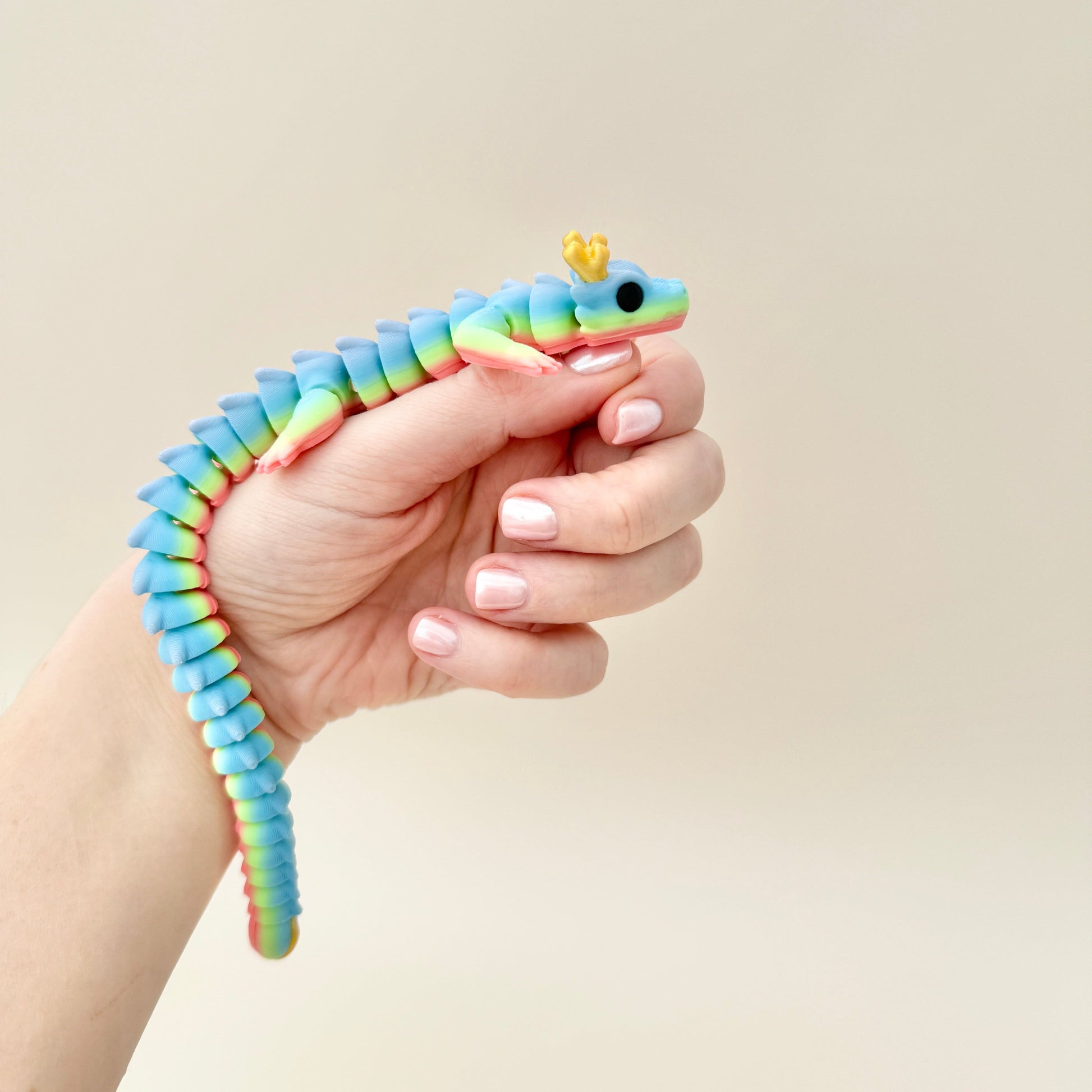 Mystic Dragon fidget toy with a rainbow body, gold horns, and black eyes, fully articulated for sensory play and collecting.