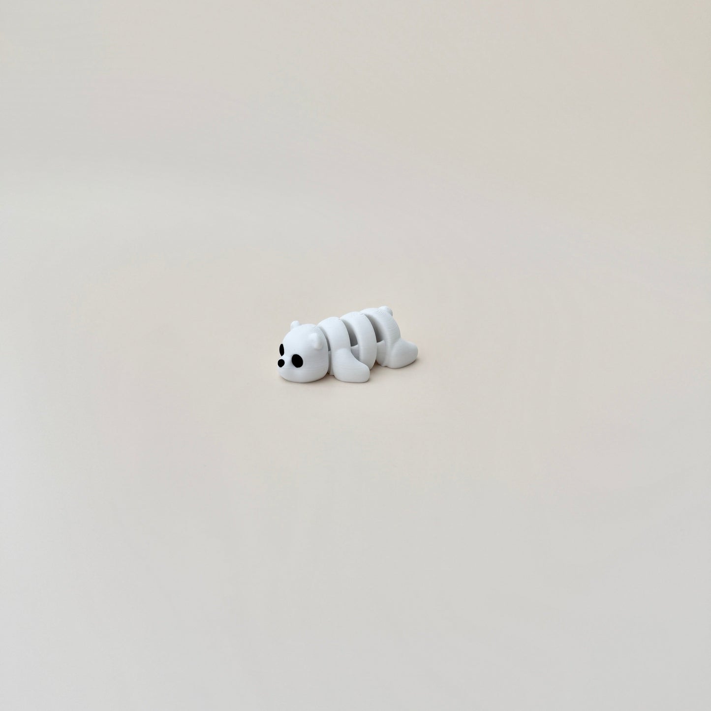 Small polar bear fidget toy, 6cm in size, white with black eyes and nose, designed for sensory engagement.