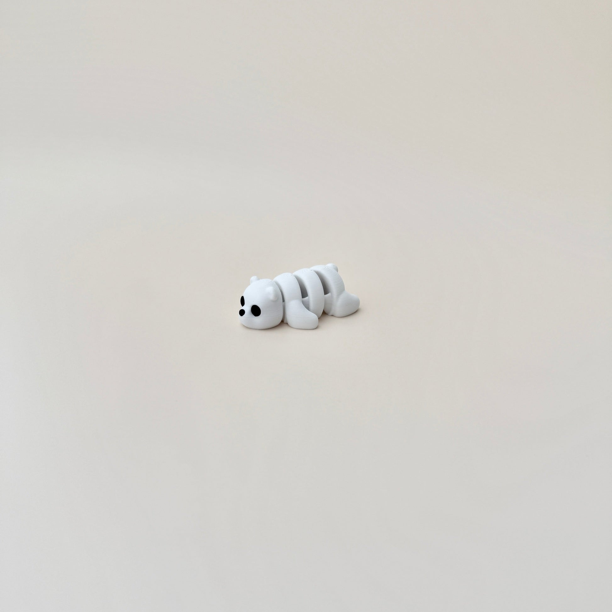 Small polar bear fidget toy, 6cm in size, white with black eyes and nose, designed for sensory engagement.