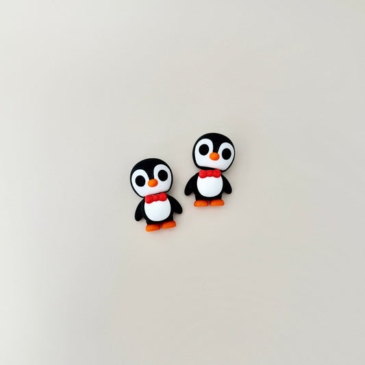 Black and white penguin fidget toy with orange beak and red bow tie, featuring an articulated head for fidgeting.