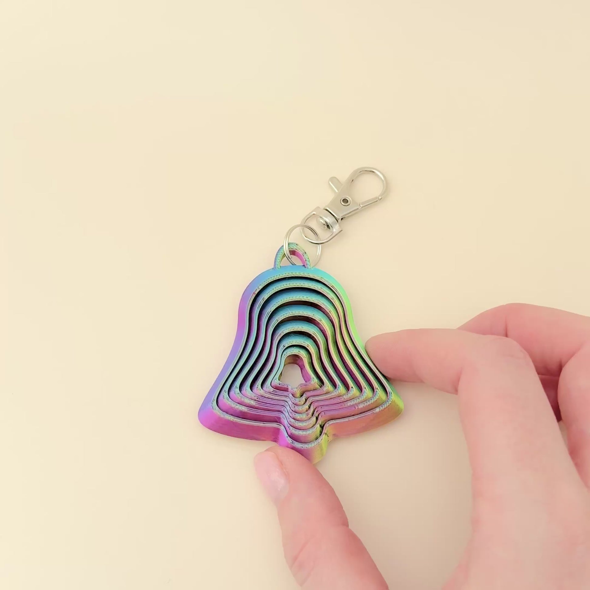 Christmas bell-shaped fidget keyring with cascading layers, finished in a vibrant colour-changing filament.