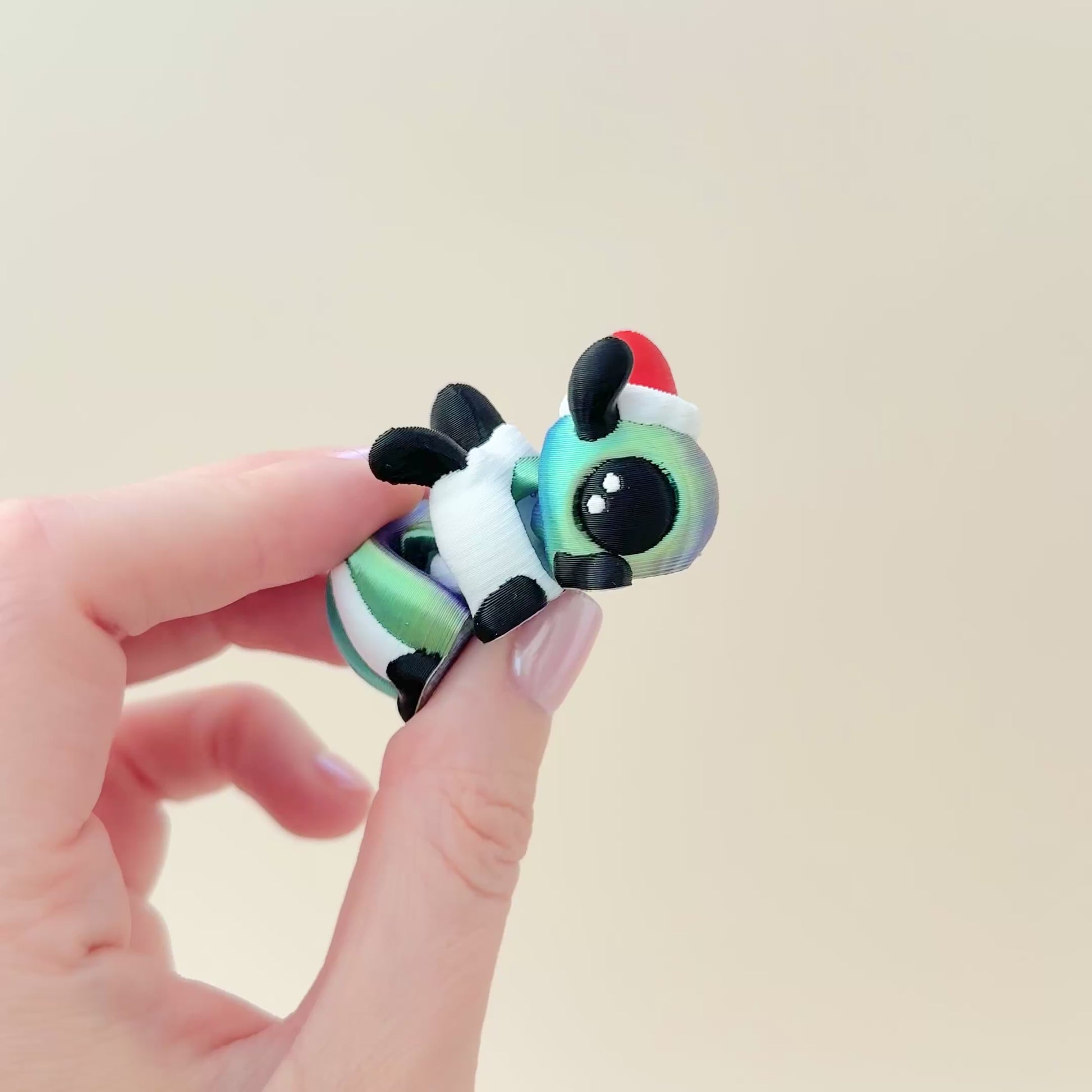 5cm bug fidget toy featuring a colour-changing blue-to-green design and festive accents.