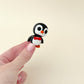 Compact penguin fidget toy, black and white with a red bow tie, perfect for sensory engagement and fidgeting.