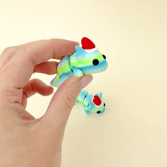 Cute axolotl fidget toy in green and blue gradient colours, with a holiday hat and articulated design for sensory play.